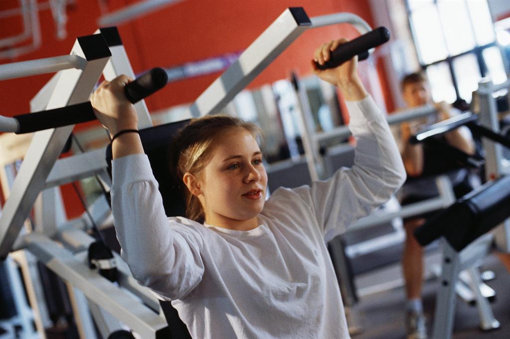 teen girl lifting weights to help with back pain